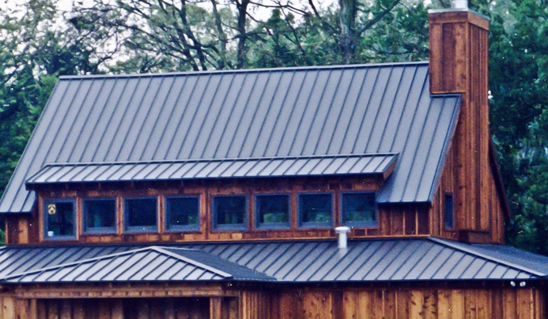 Metal roof on nice home in the woods to illustrate Metal Roof Architecture: Form + Function + Longevity