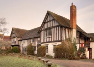 Double gabled, timber-framed Tudor period house showing different roof geometry styles.