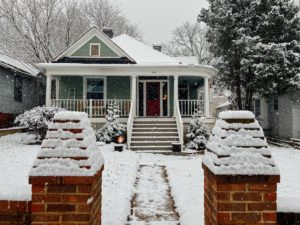 A craftsman bungalow style house covered in snow, showing a different roof geometry type