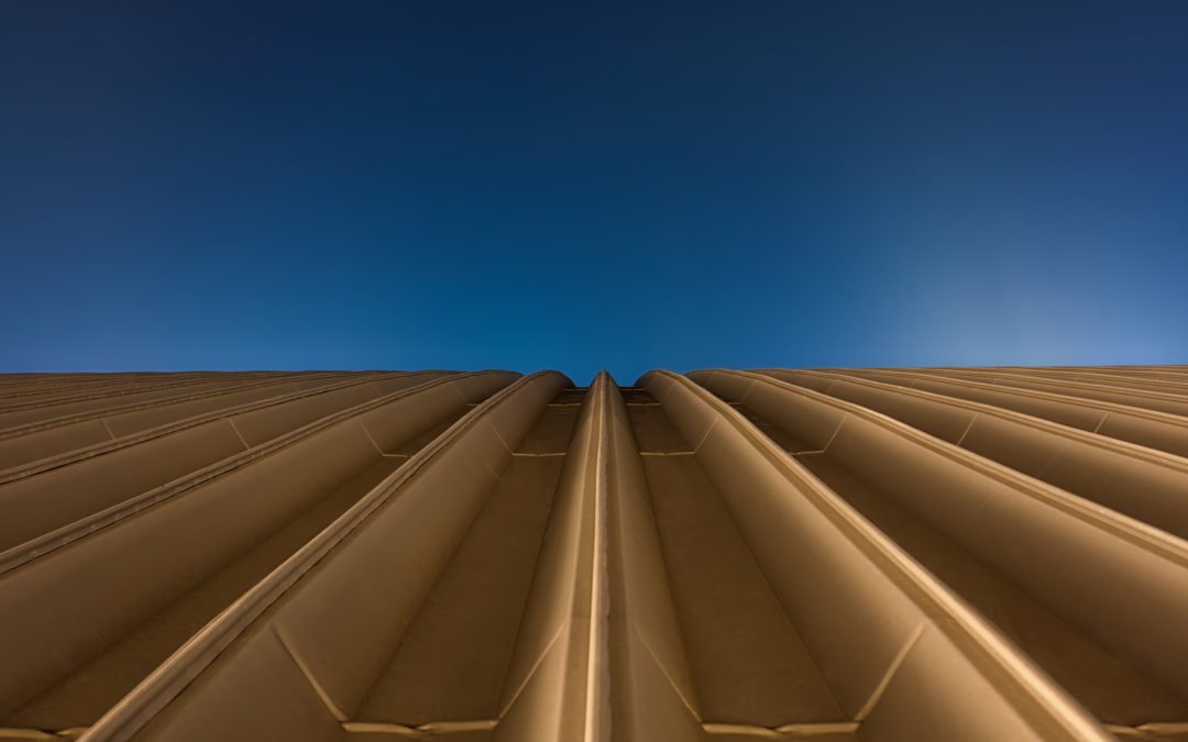 Golden rooftop of a hall with blue sky background to illustrate are metal roofs noisy