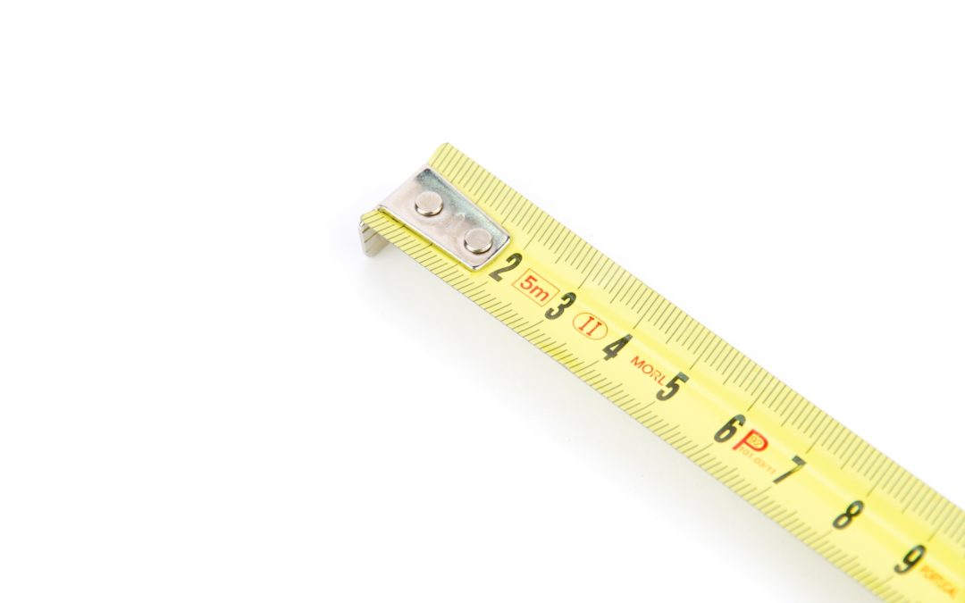 measuring tape on a white background to illustrate How Wide Is Metal Roofing
