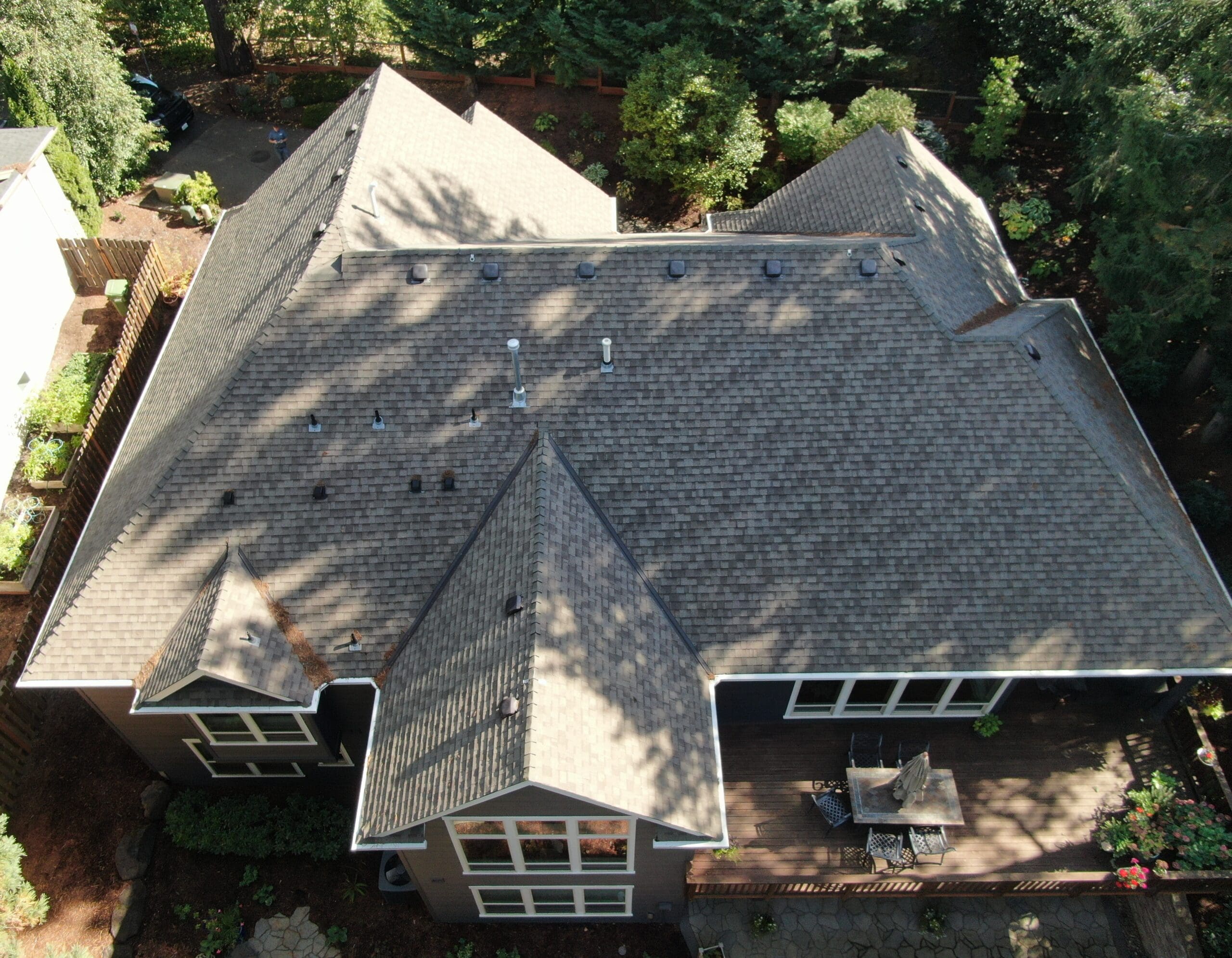 Aerial shot of a traditional asphalt roof in need of a new roof to help illustrate Are Metal Roofs Cooler Than Shingles
