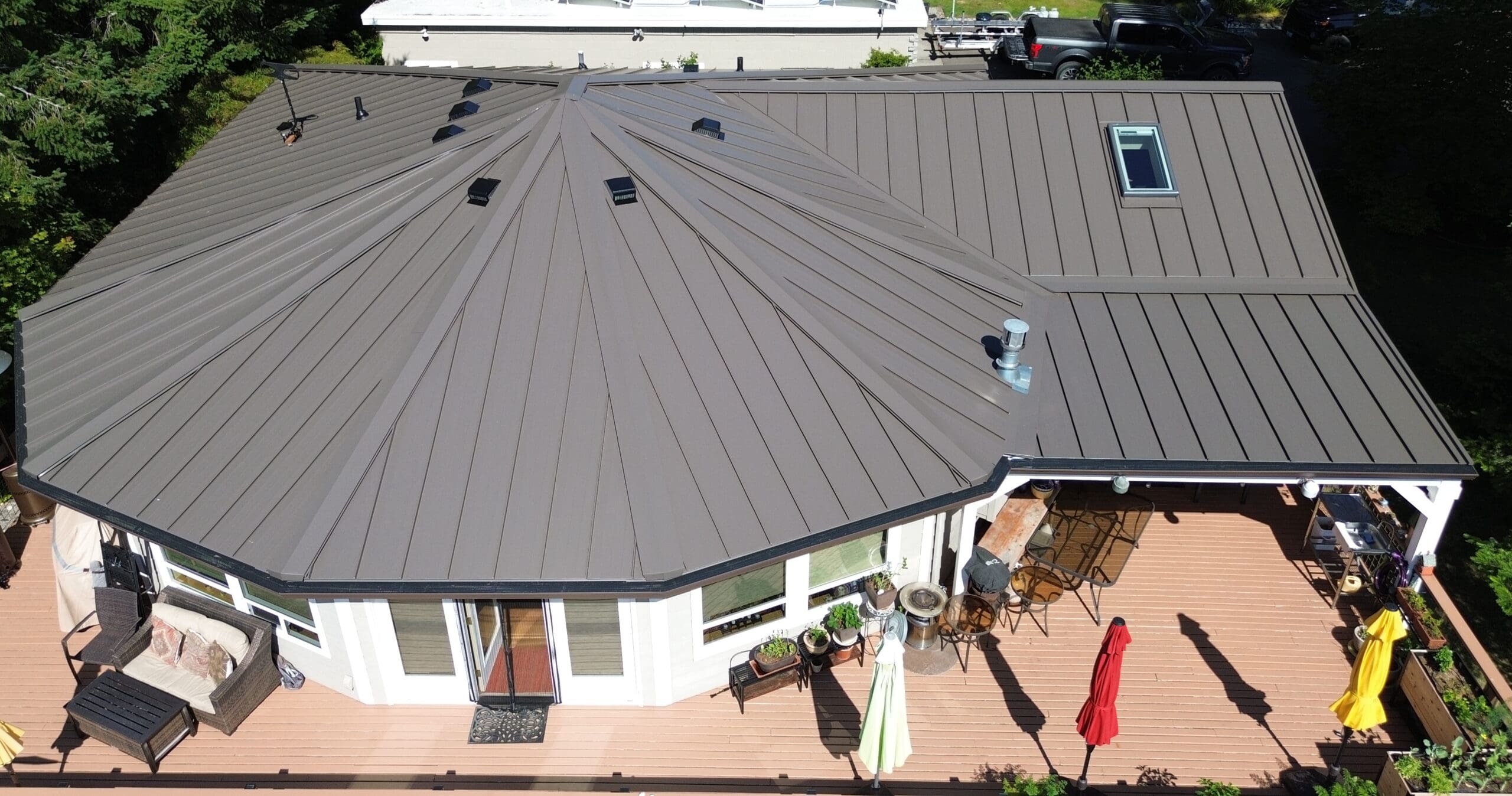 Medium Bronze Standing Seam roofing on a white home to illustrate metal roofing types