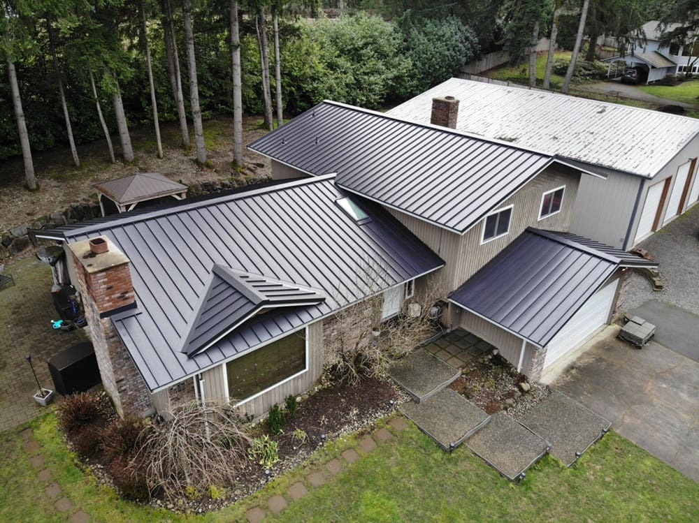 A metal roof on a home in a wooded area.